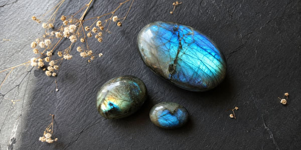 labradorite polie avec labradorescence bleue et verte sur fond sombre, pierre de protection en lithothérapie