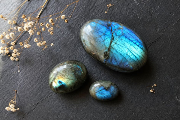 labradorite polie avec labradorescence bleue et verte sur fond sombre, pierre de protection en lithothérapie