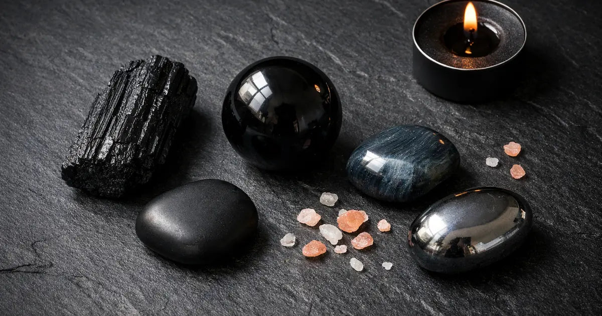 collection de pierres noires en lithothérapie tourmaline obsidienne onyx oeil de faucon sur fond sombre
