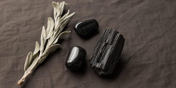 tourmaline noire brute et polie sur tissu naturel, pierre de protection et d'ancrage en lithothérapie