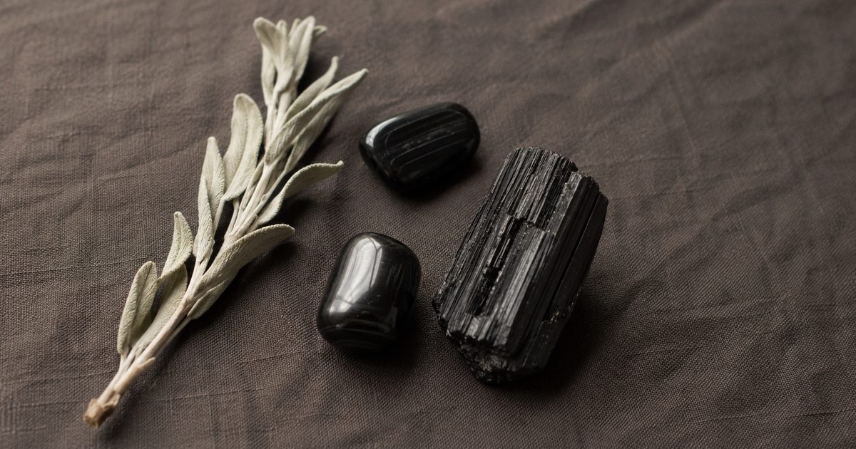 tourmaline noire brute et polie sur tissu naturel, pierre de protection et d'ancrage en lithothérapie